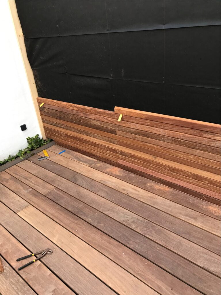 Ny træterrasse under konstruktion med værktøj på gulvet.